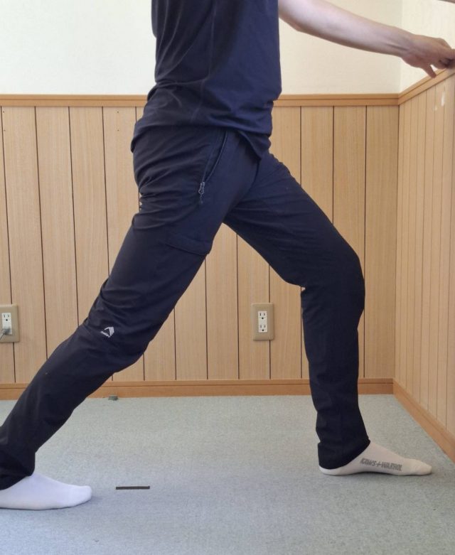 壁を持ってふくらはぎを伸ばす
